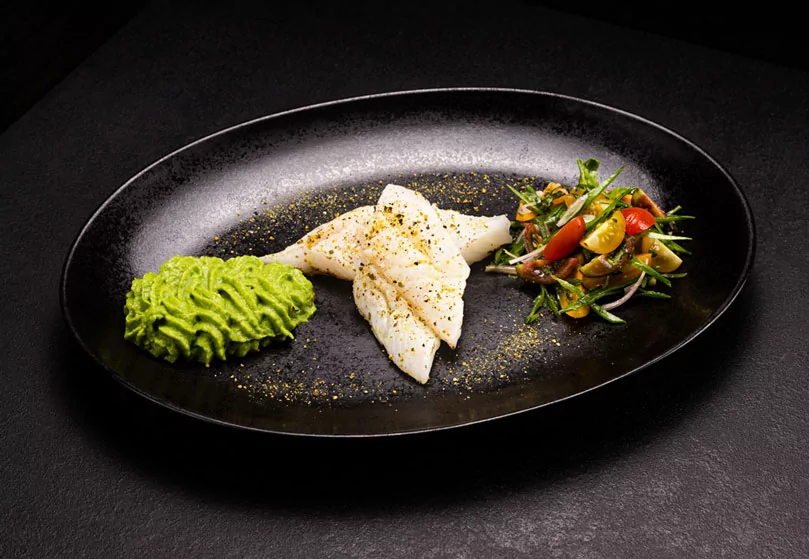 Gebratenes Kabeljaufilet auf Erbsenpüree und Zuckerschotensalat